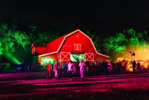 An image of a red painted barn, illuminated by flourescent lights