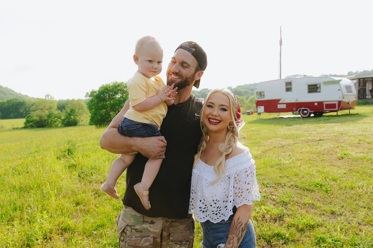 An image of country music singer, Raelynn, and her husband Josh, and her daughter, Daisy