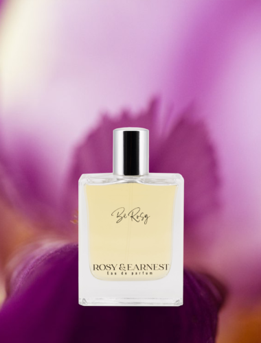 An image of the Be Rosy perfume bottle with a colorful, floral backdrop