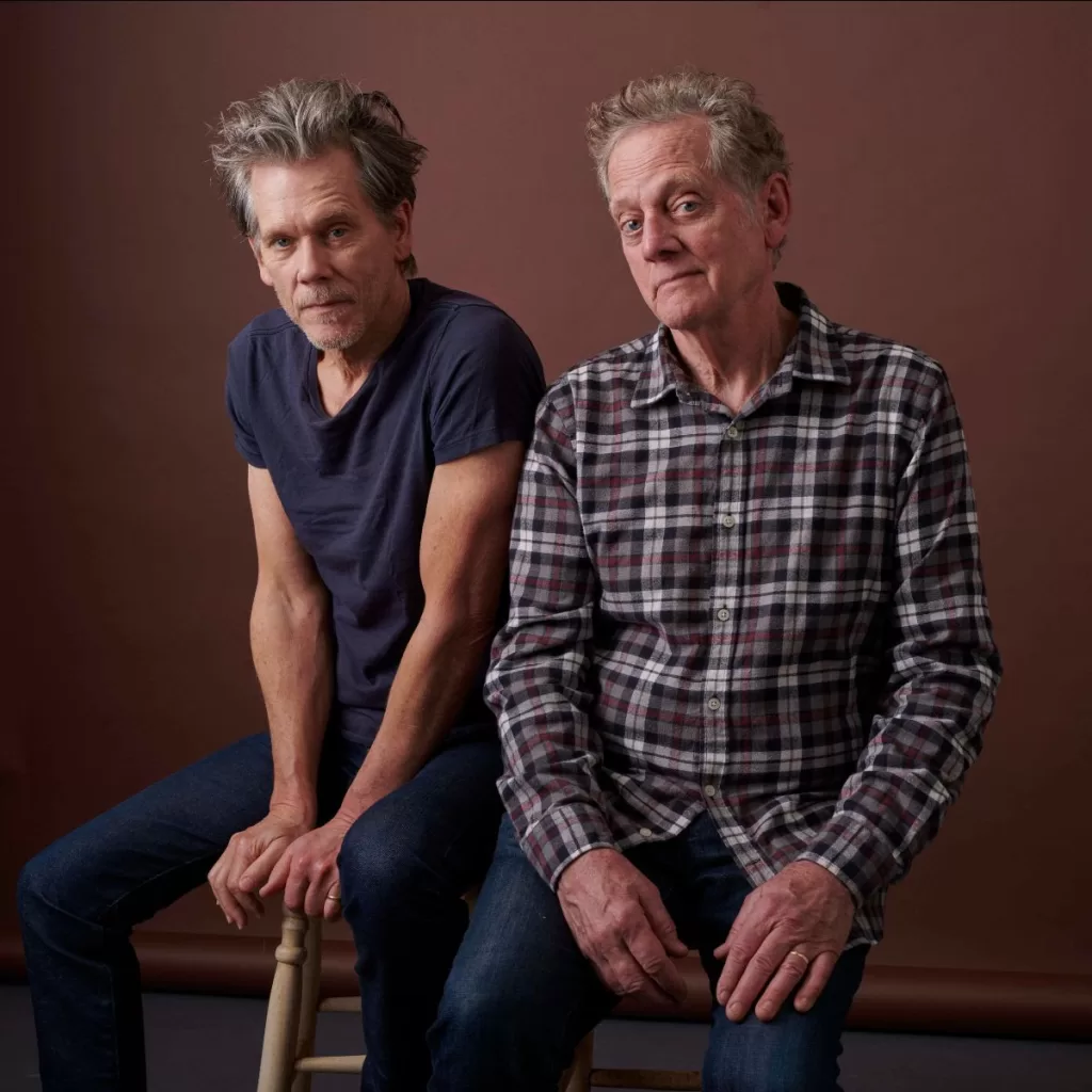 An image of music and brother duo, The Bacon Brothers, with Kevin Bacon, also an actor on the left, and Michael Bacon on the right.