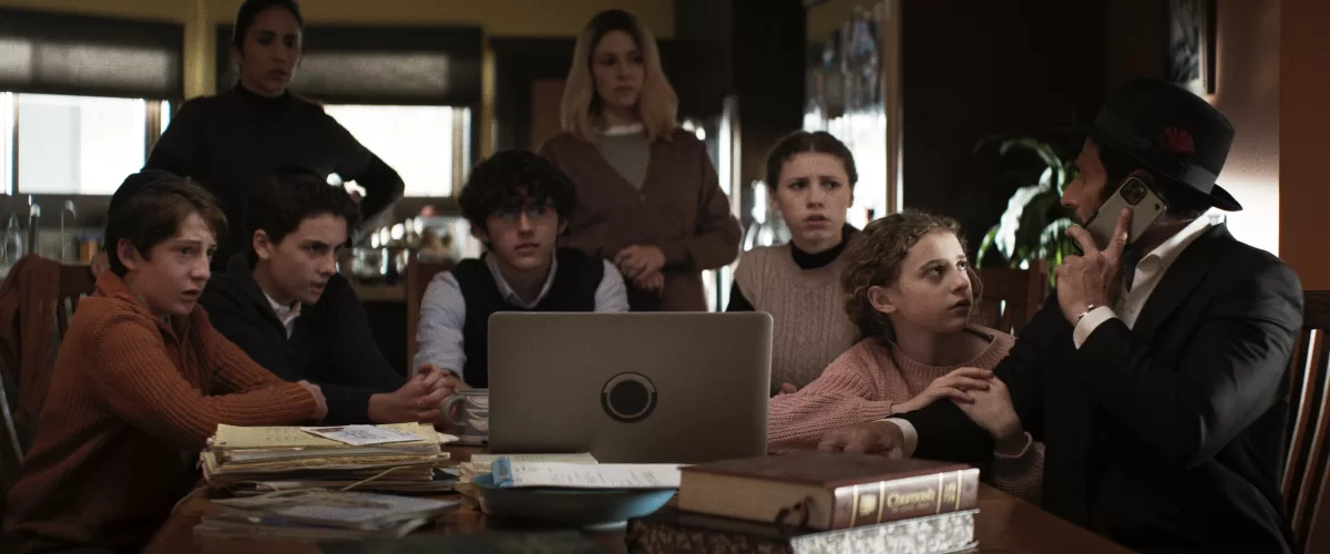 A still image from the new film, 'Guns and Moses,' featuring family members sitting around a computer
