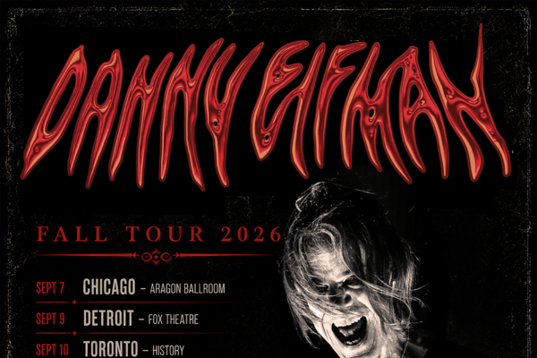 An image of Danny Elfman, standing, laughing wide, with his tour dates listed next to him on the left side of the image.